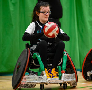 A female player in a black vest looks to inbound the ball to her team mates.