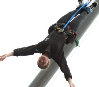 Tayla as she falls following her bunjee jump, her arms wide above her head as she free falls