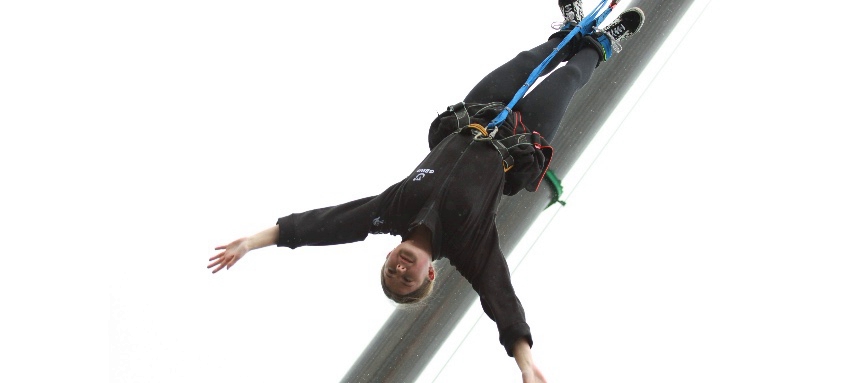 Tayla as she falls following her bunjee jump, her arms wide above her head as she free falls
