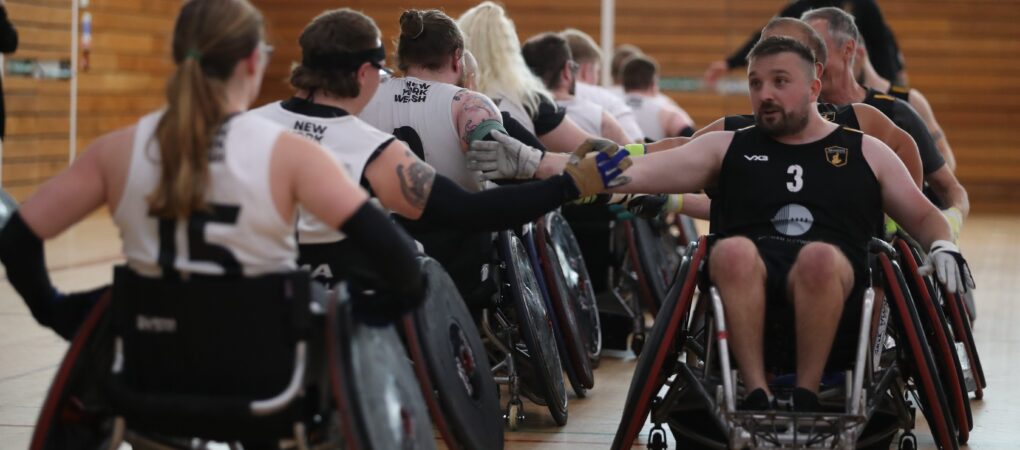 two teams line-up to shake hands following a game of wheelchair rugby