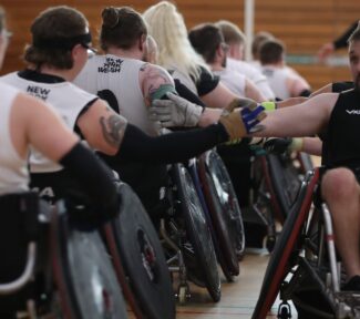 two teams line-up to shake hands following a game of wheelchair rugby