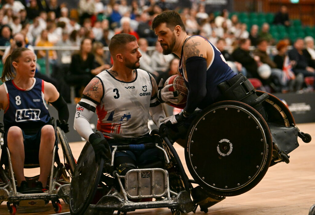 Two wheelchair rugby players collide