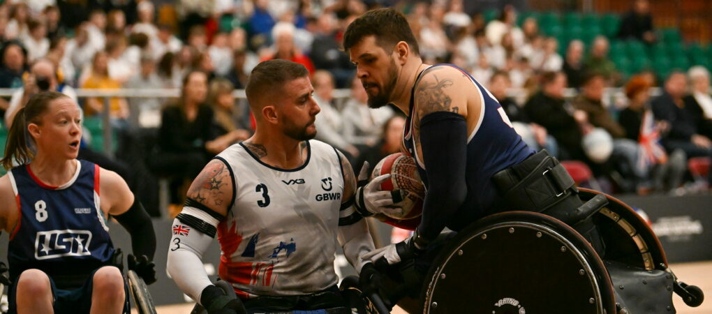 Two wheelchair rugby players collide