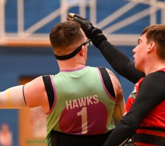 Luke Collier holding the ball in a wheelchair rugby game