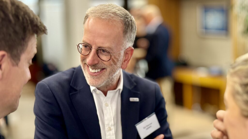 Man smiling at networking event.