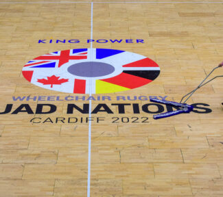 Volunteer cleaning floor at Quad Nations