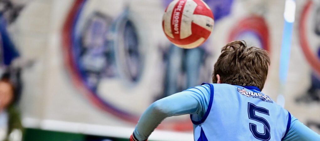 Female wheelchair rugby player chasing the ball