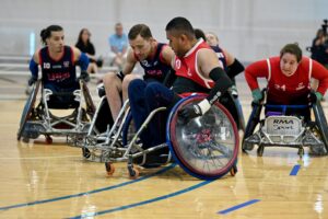 two wheelchair rugby players battling off the ball. one male from GB and one male from USA
