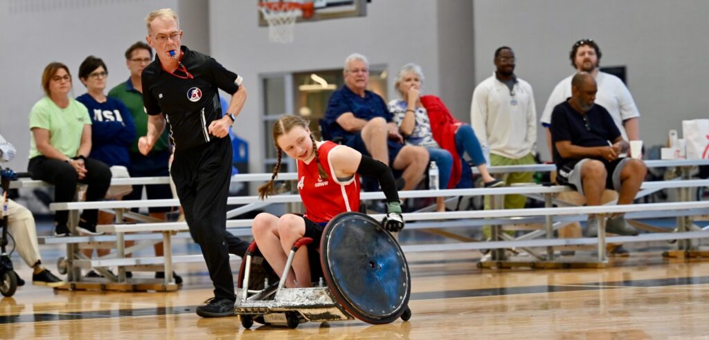 Female Wheelchair rugby player on a court sprinting on her own